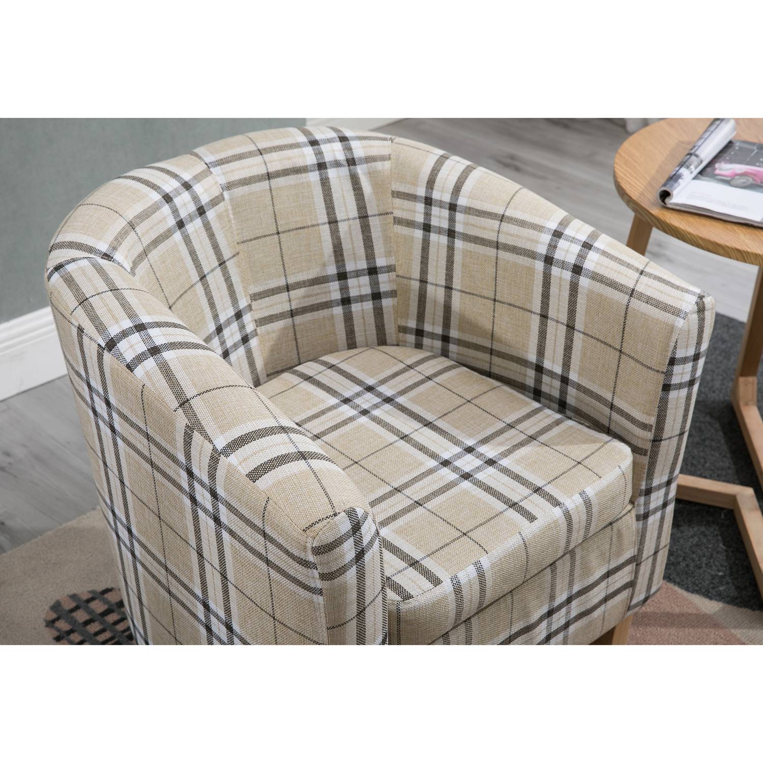 Cream checkered tub chair in a room with a side table and rug.
