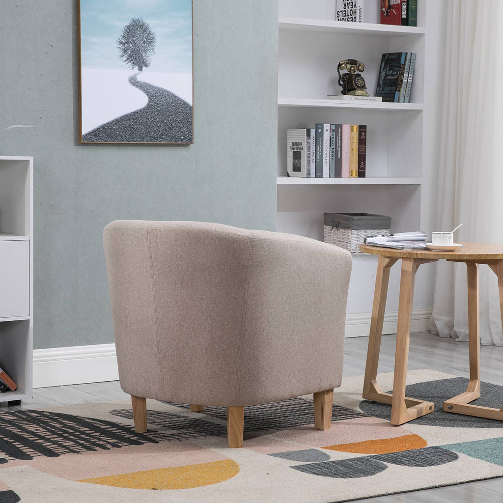 Cream tub chair in a living room with a bookshelf and small table.