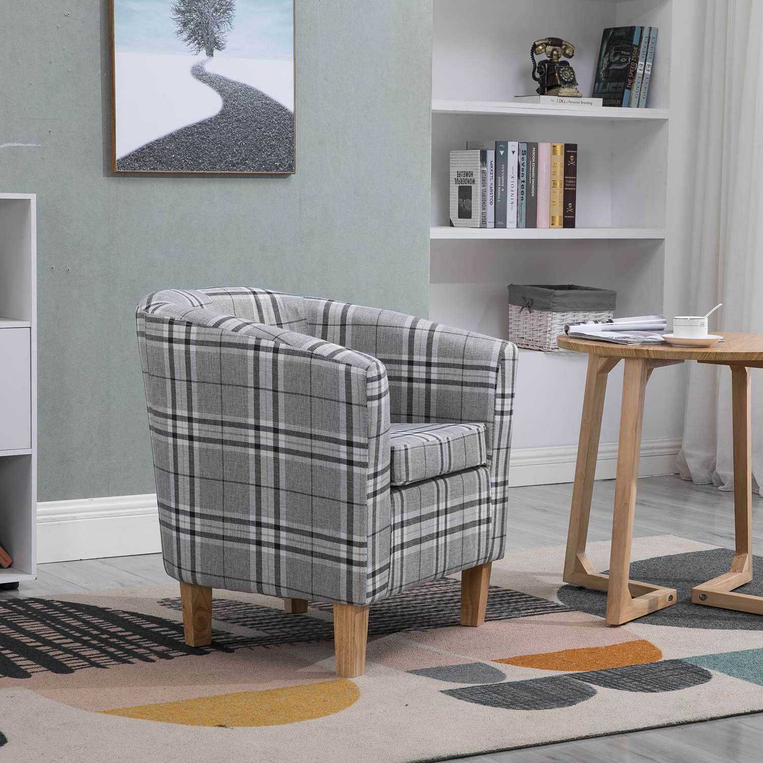 Grey checkered tub chair in a living room setting with a bookshelf and small table.