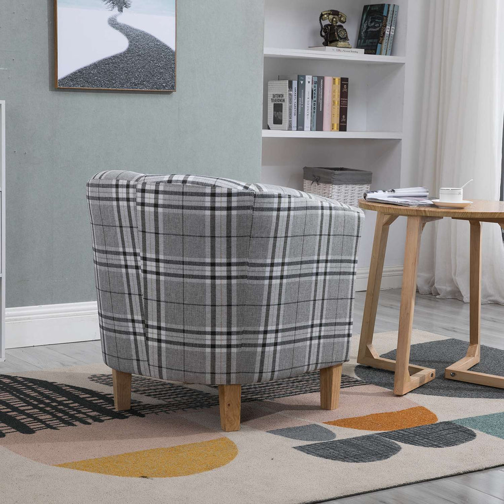 Grey checkered tub chair in a living room setting with a side table and books.