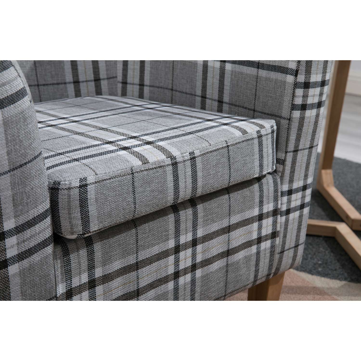 Grey checkered tub chair with a cushioned seat on a light wooden floor.