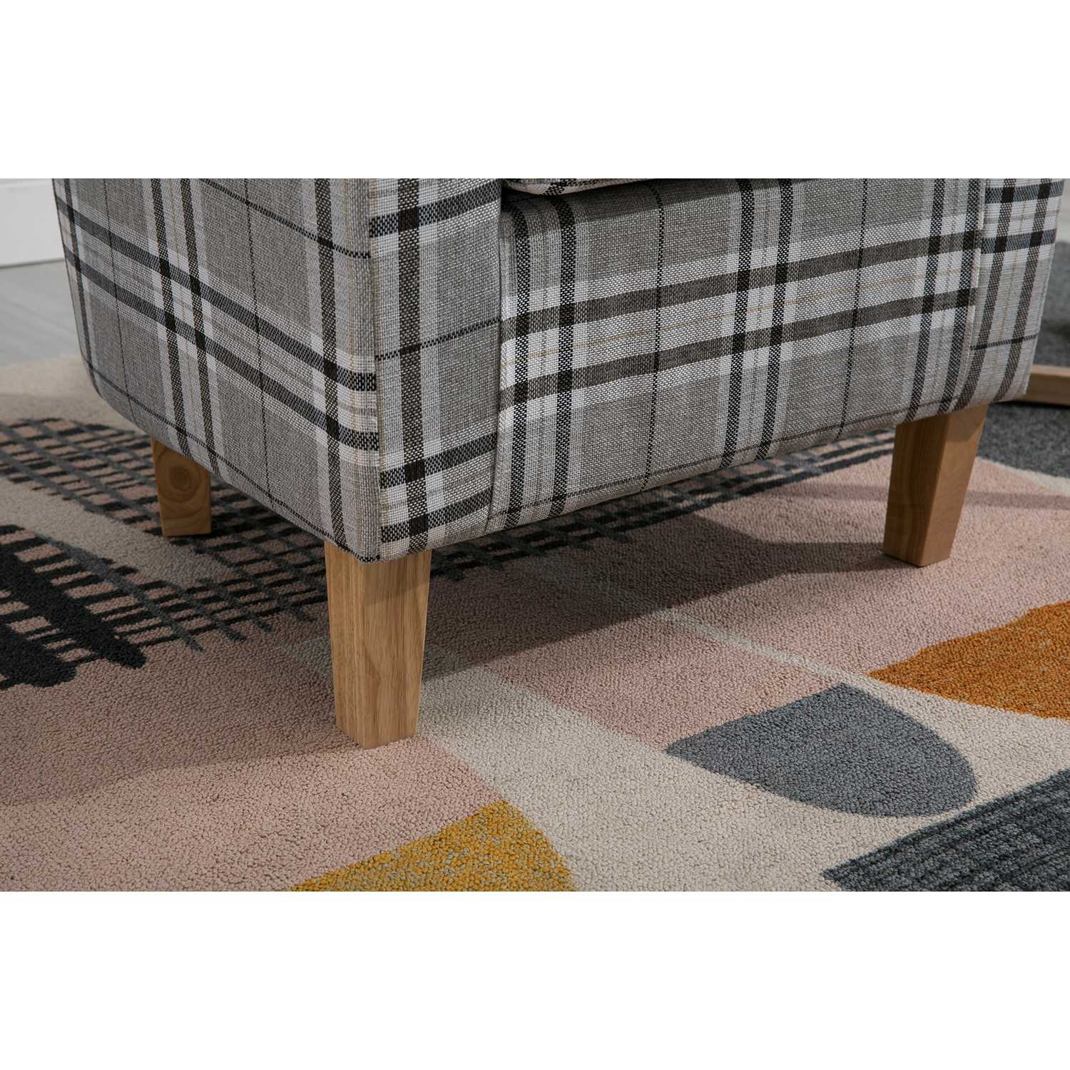 grey checkered tub chair with wooden legs on a geometrically patterned rug