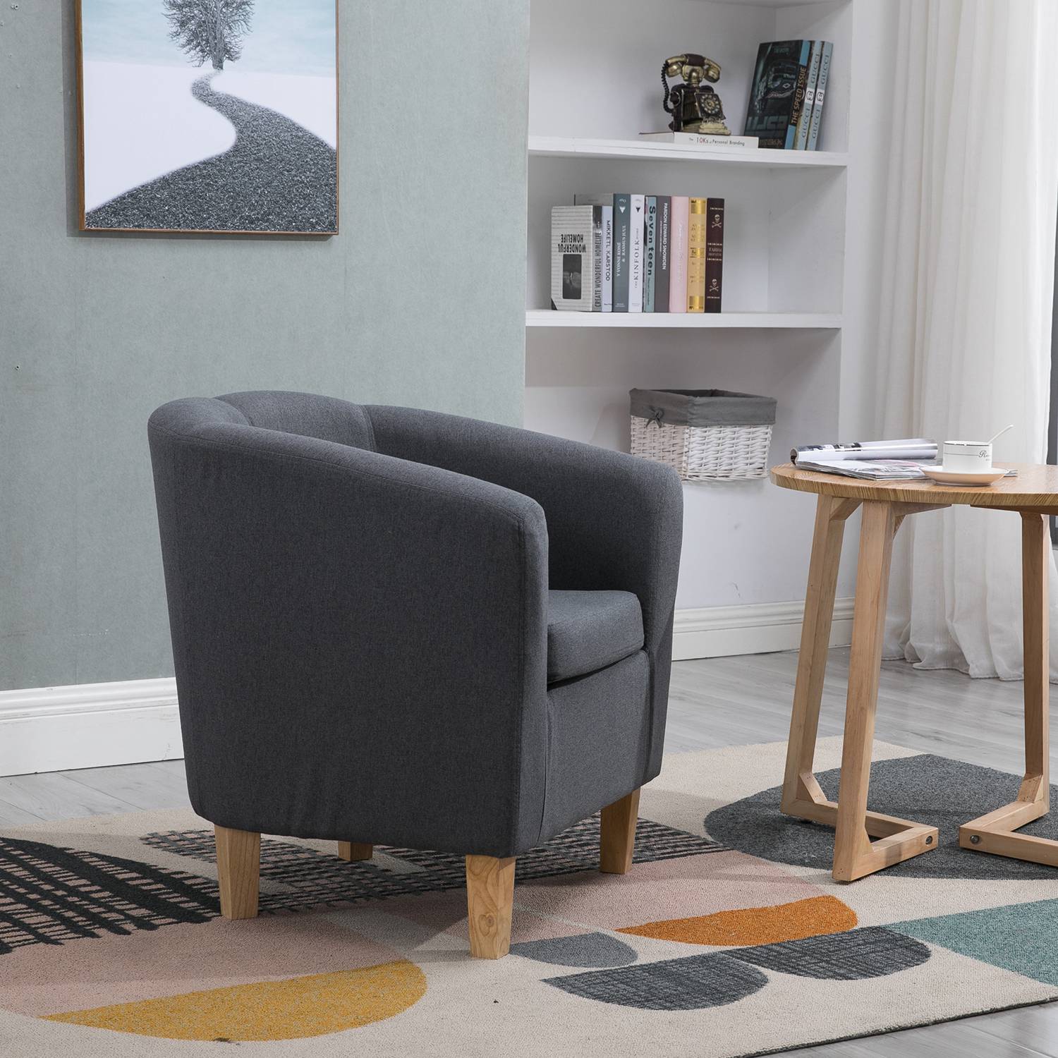 Side view of fabric grey tub chair in a living room setting.