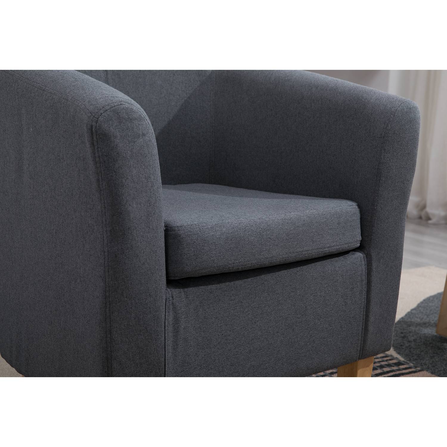 grey fabric tub chair in a living room setting. 