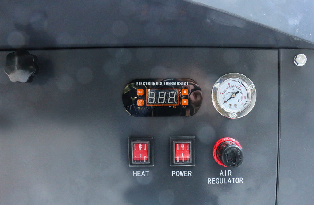 Control panel with digital thermostat, switches, and gauge from a industrial parts washer on a dark background. 