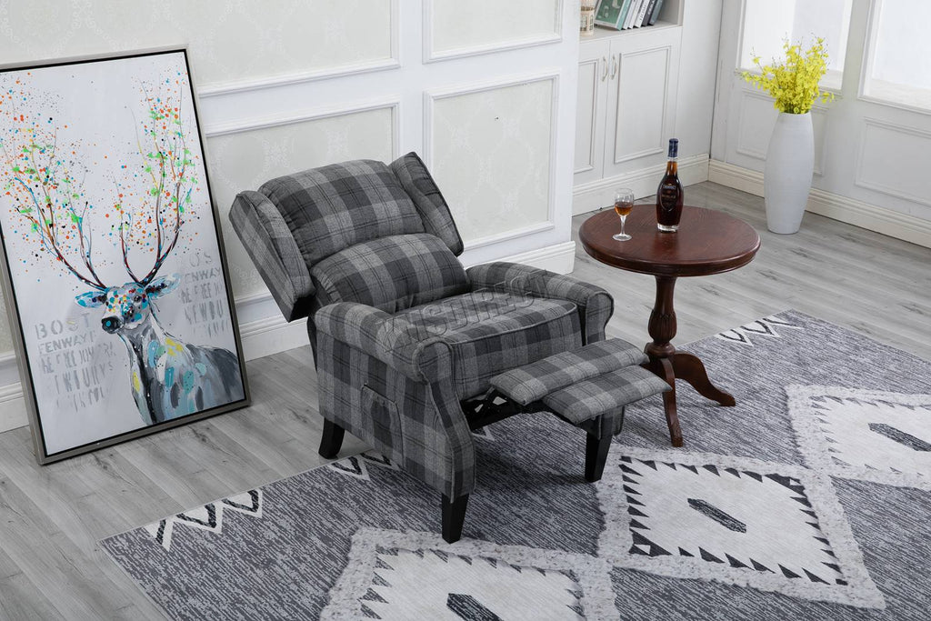 Grey checkered recliner armchair in a living room with a rug and decorative items.