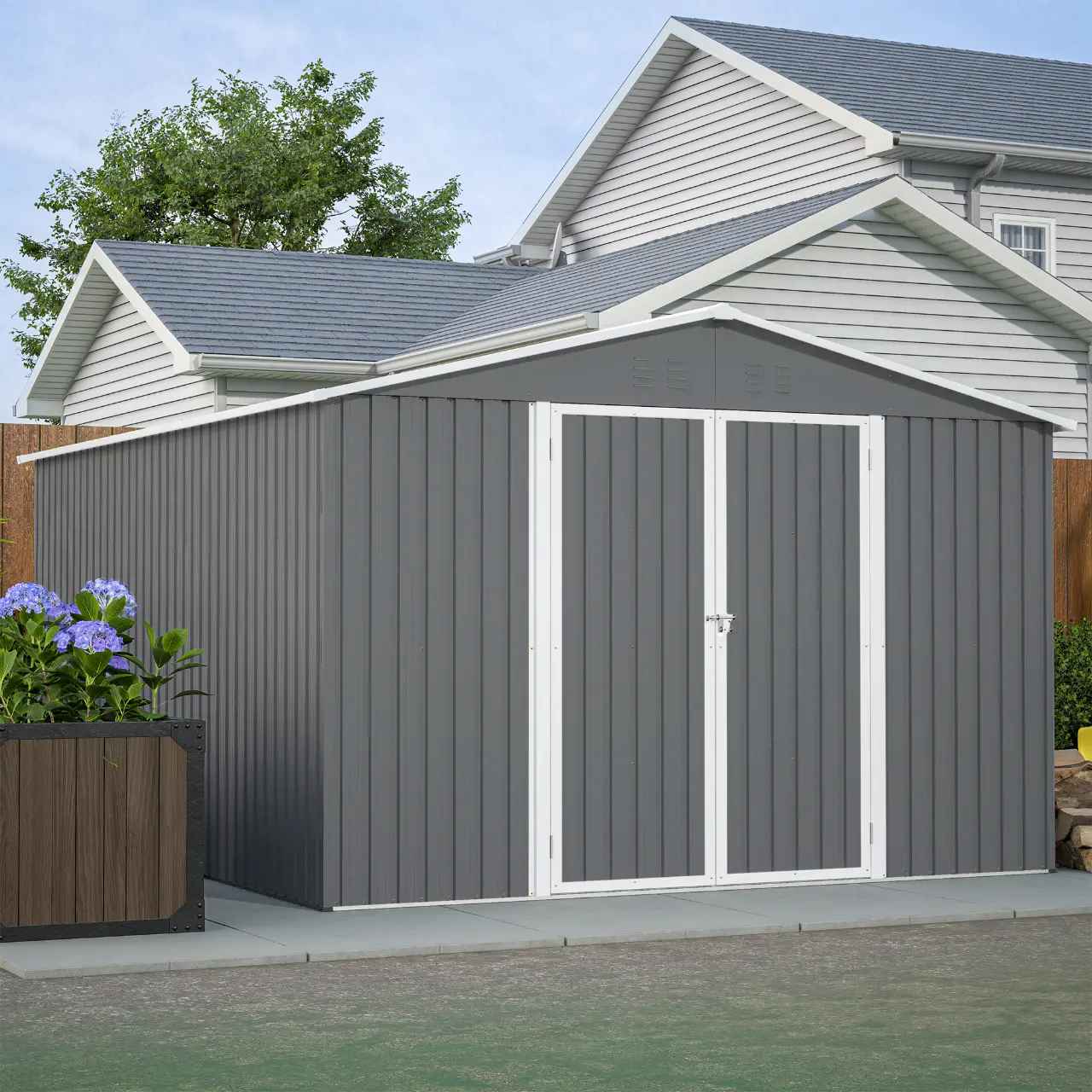 Grey garden shed with an apex roof in front of a house.