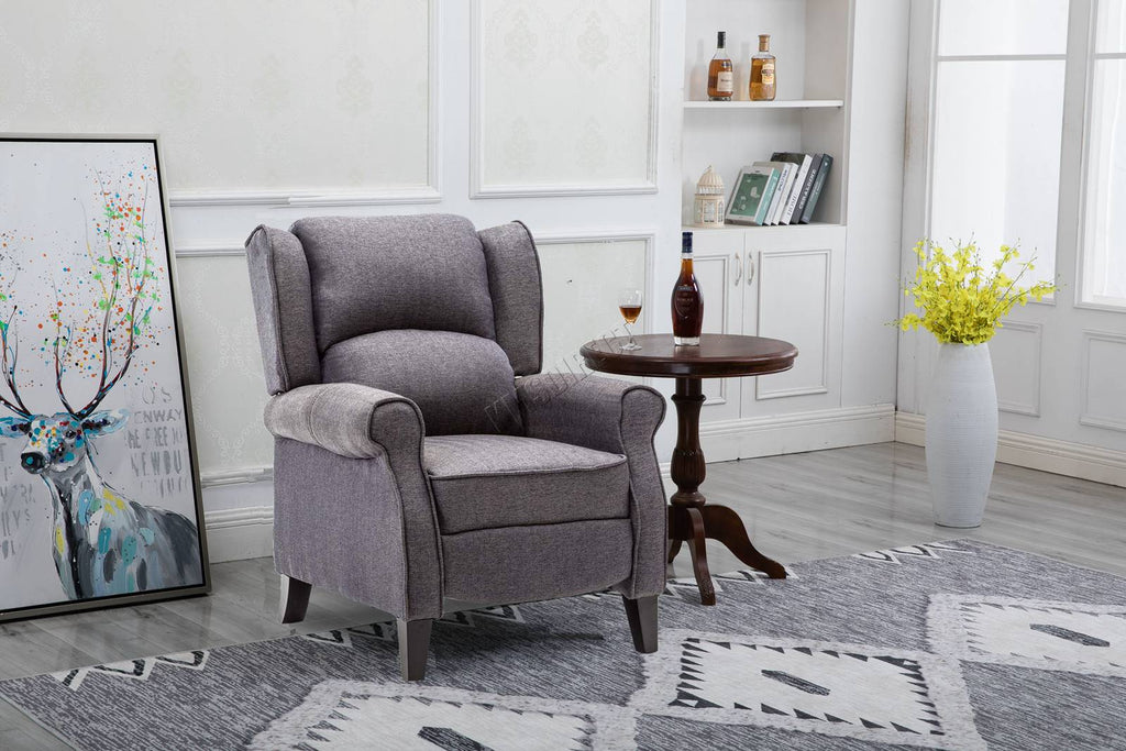 Grey recliner armchair in a living room setting with a side table and decorative items.