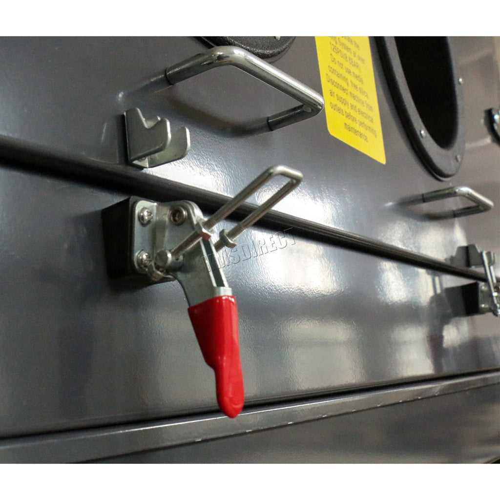 Metal latch with red handle on a metallic surface from a sandblasting machine