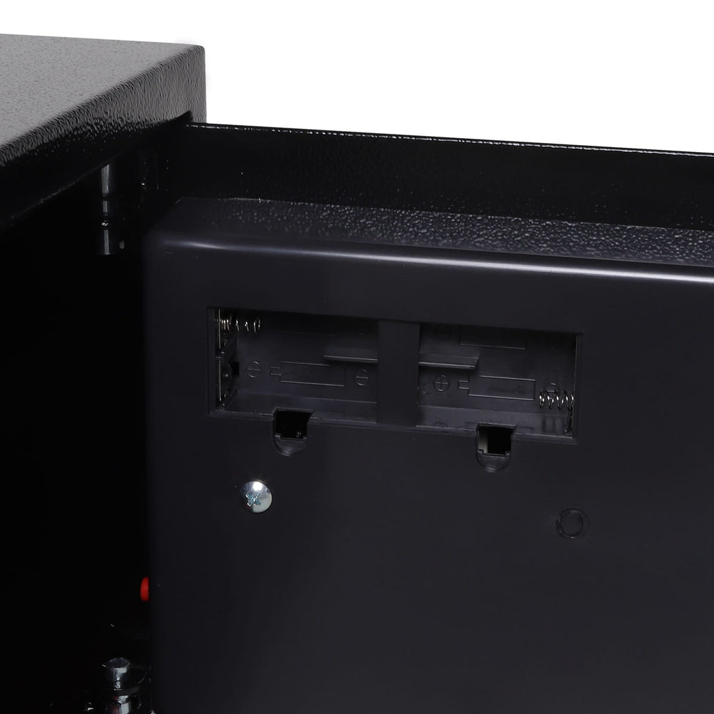 Close-up of a black electronic device with battery placement from a security safe on a white background