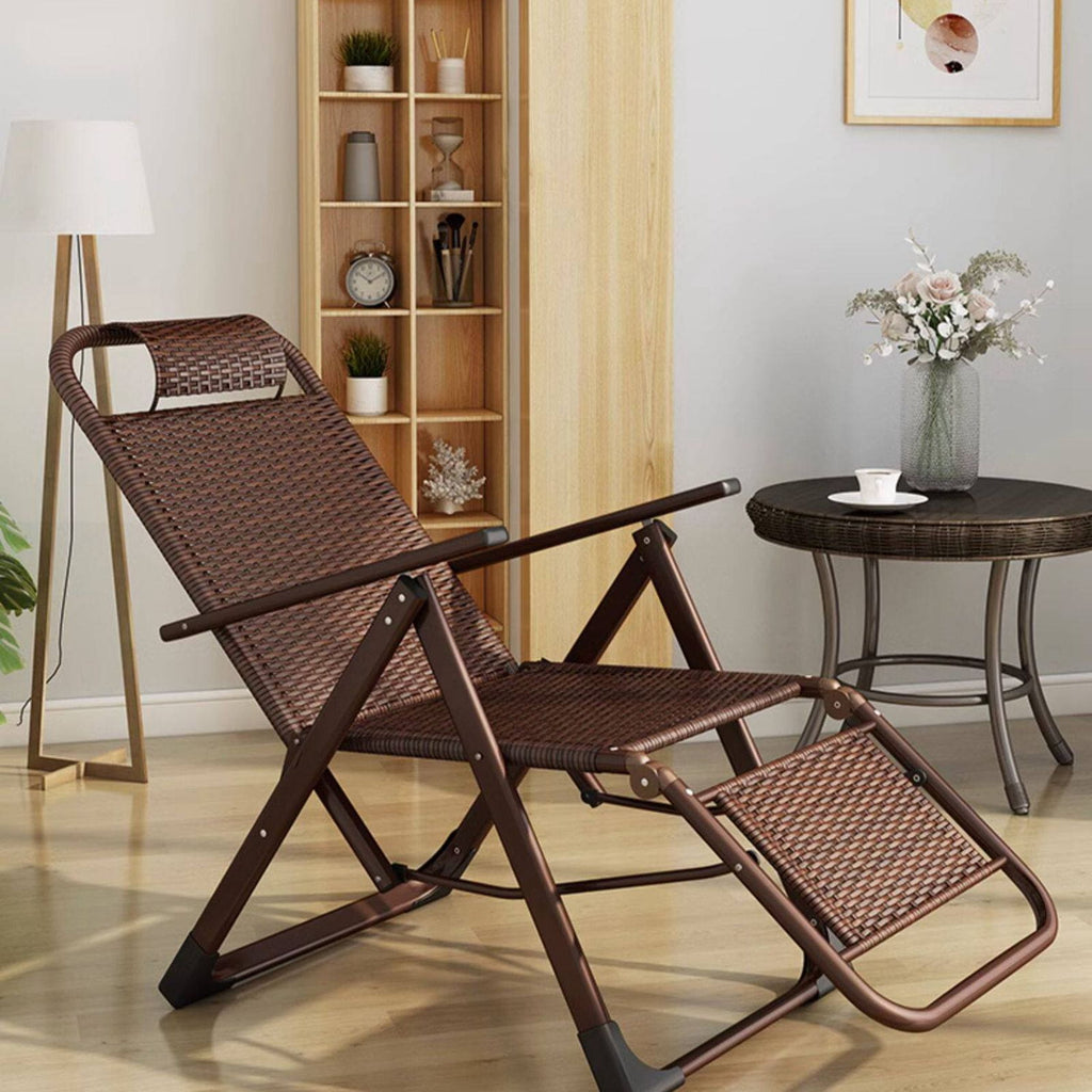Brown rattan outdoor recliner chair in a room with a bookshelf and small table.