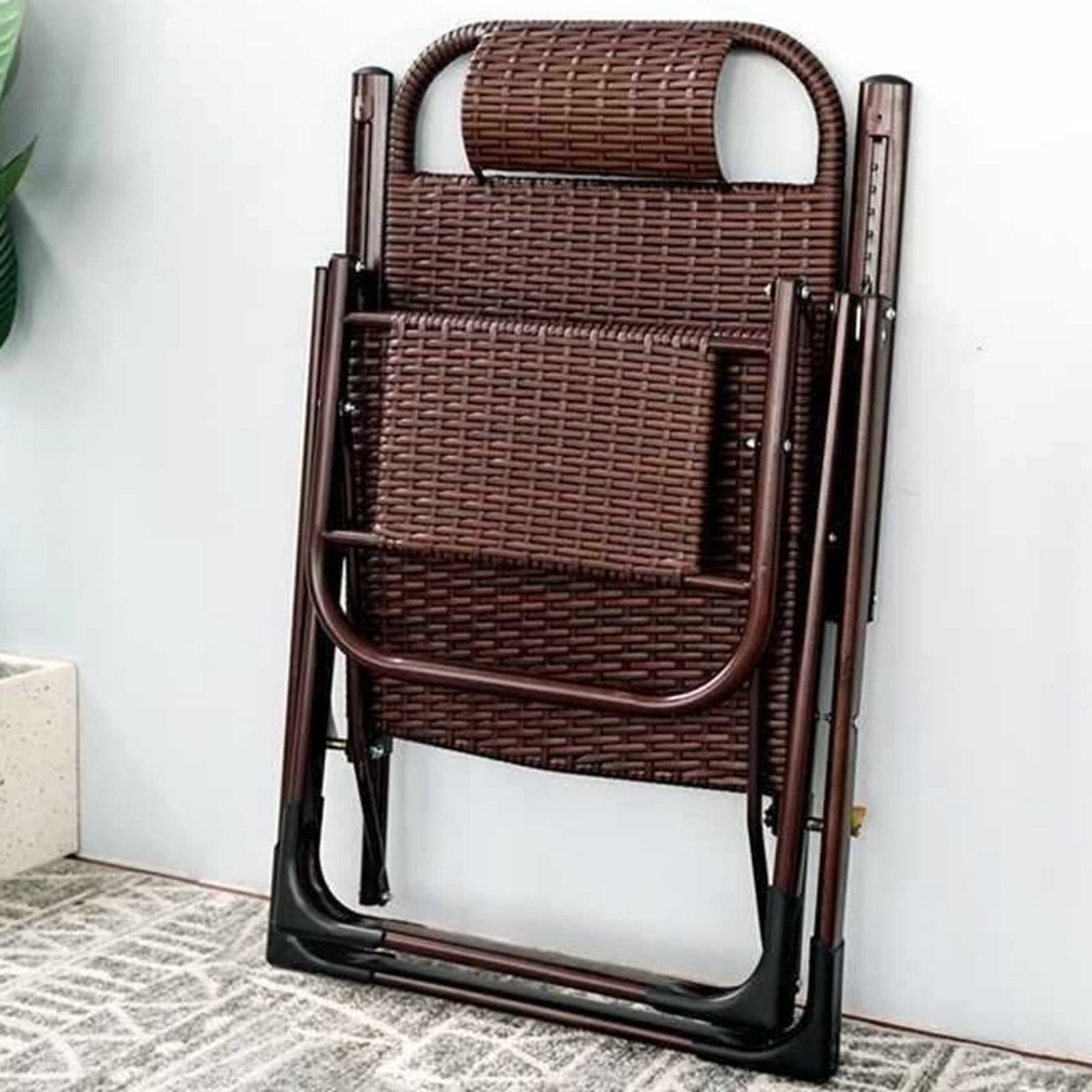 Brown outdoor recliner chair against a white wall.