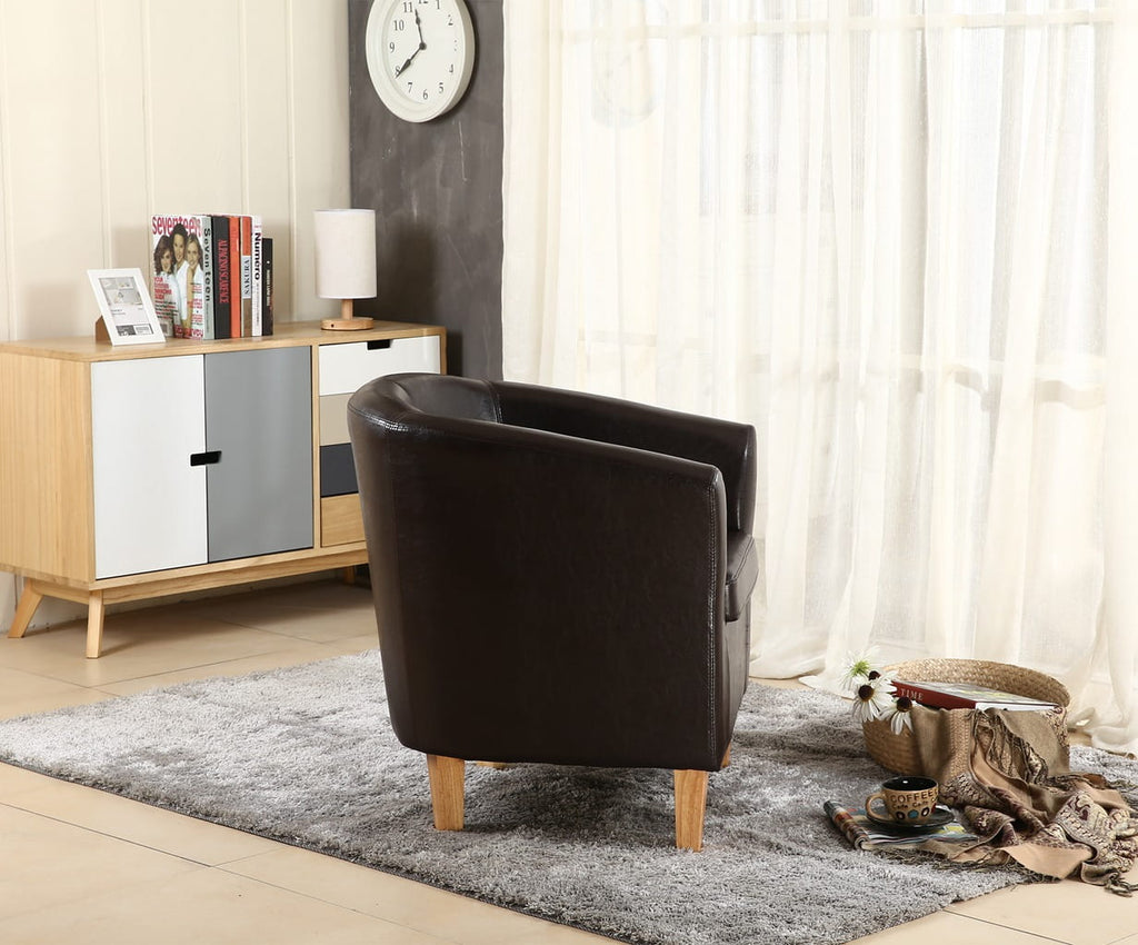 Brown faux leather armchair in a living room with a sideboard and decor items.