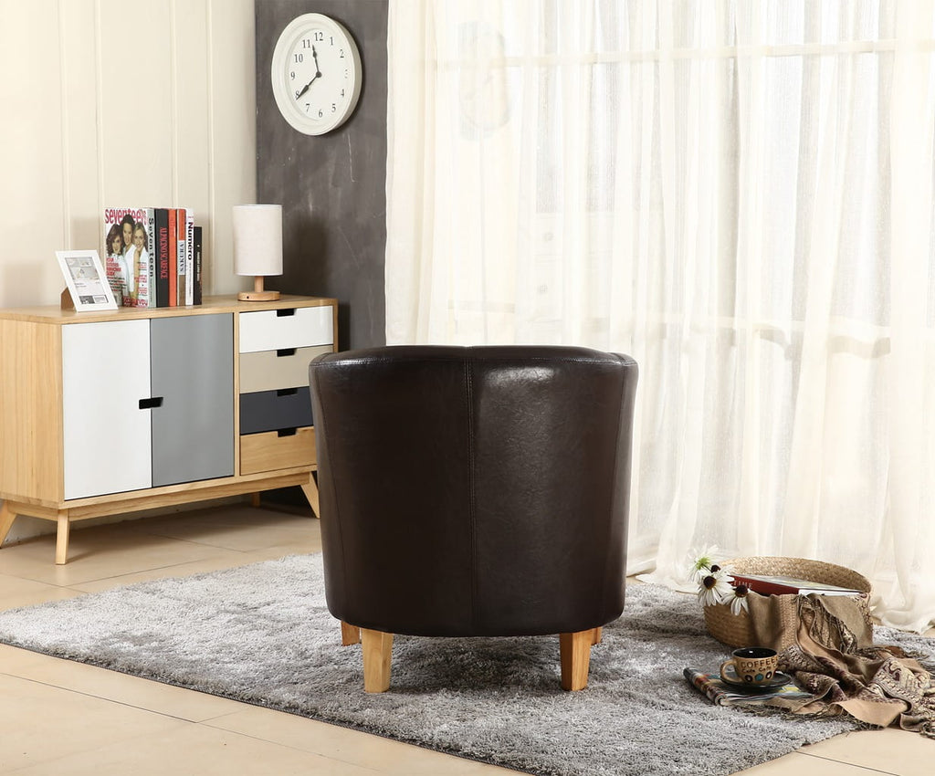 Brown faux leather armchair in a living room setting with a sideboard and clock.