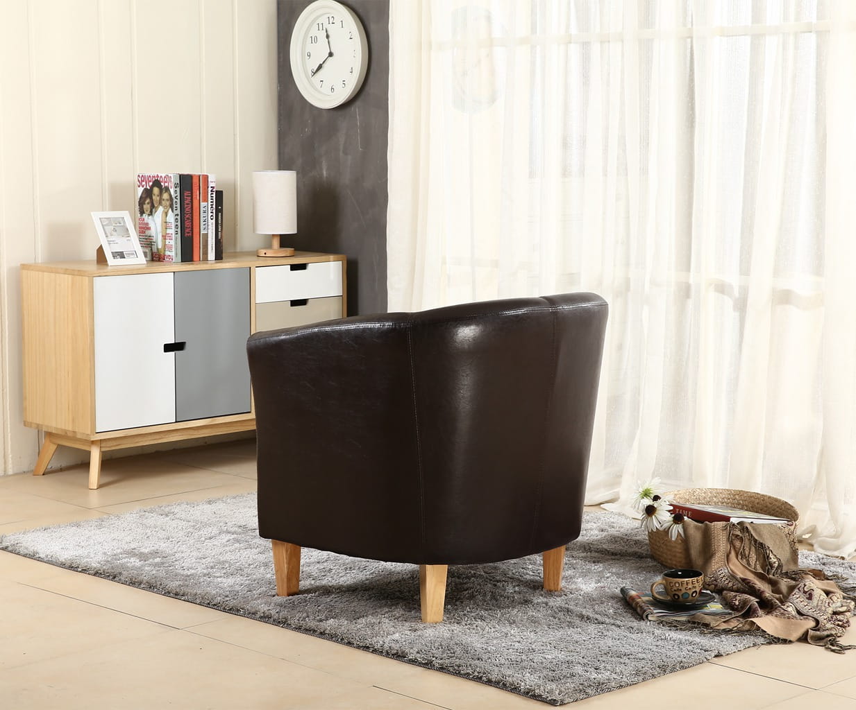 Brown faux leather armchair in a living room setting with a sideboard and clock.
