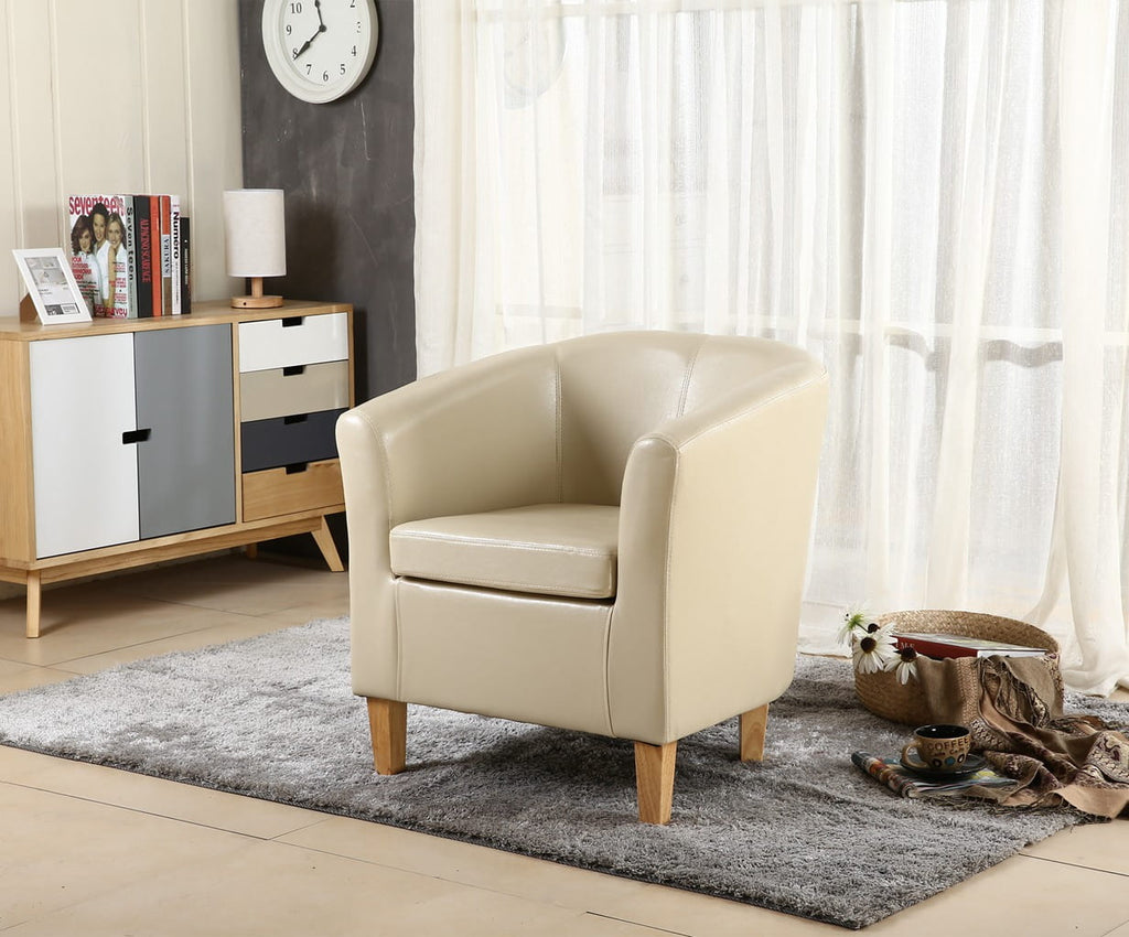 Ivory faux leather armchair in a living room setting with a cabinet and window in the background.