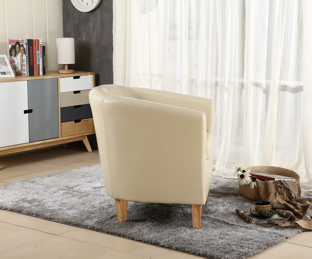 Ivory faux leather armchair in a living room setting with a sideboard and curtains.