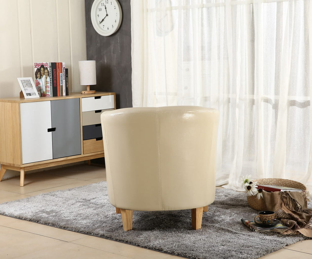 Ivory faux leather armchair in a living room setting with a cabinet and clock in the background.