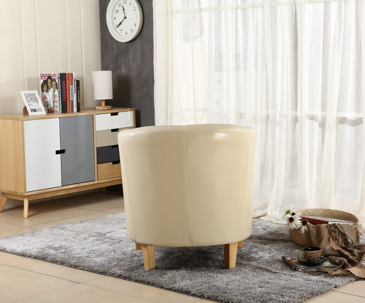 Ivory faux leather armchair in a living room setting with a cabinet and clock in the background.