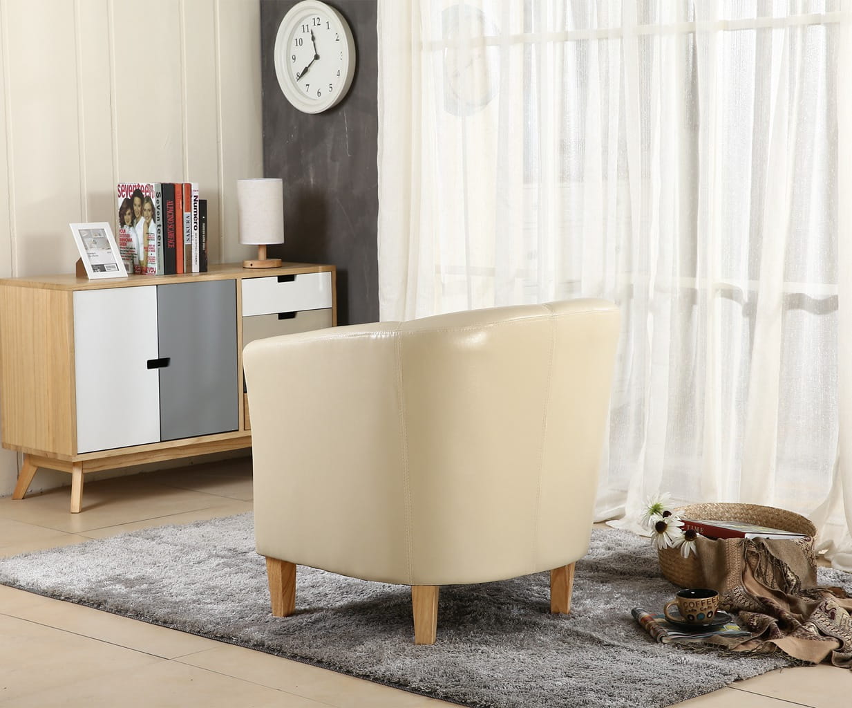 Ivory faux leather armchair in a living room with a wooden sideboard and decorative items.