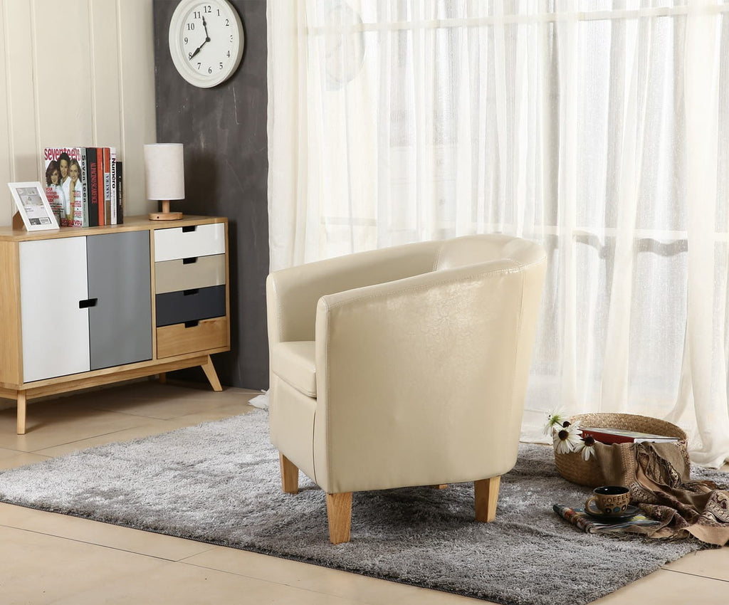 Ivory faux leather armchair in a living room with a sideboard and window curtains.