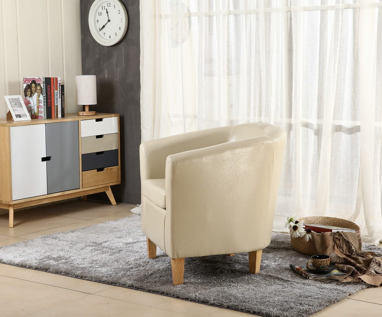 Ivory faux leather armchair in a living room with a sideboard and window curtains.
