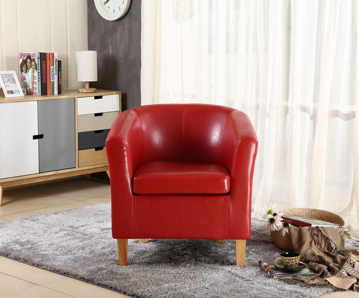 Red faux leather armchair in a living room setting with a rug, books, and a clock.
