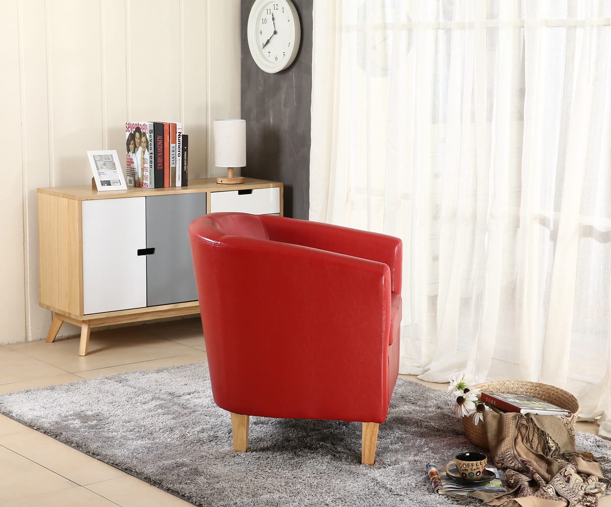 Red faux leather armchair in a living room setting with a cabinet, clock, and decor items.