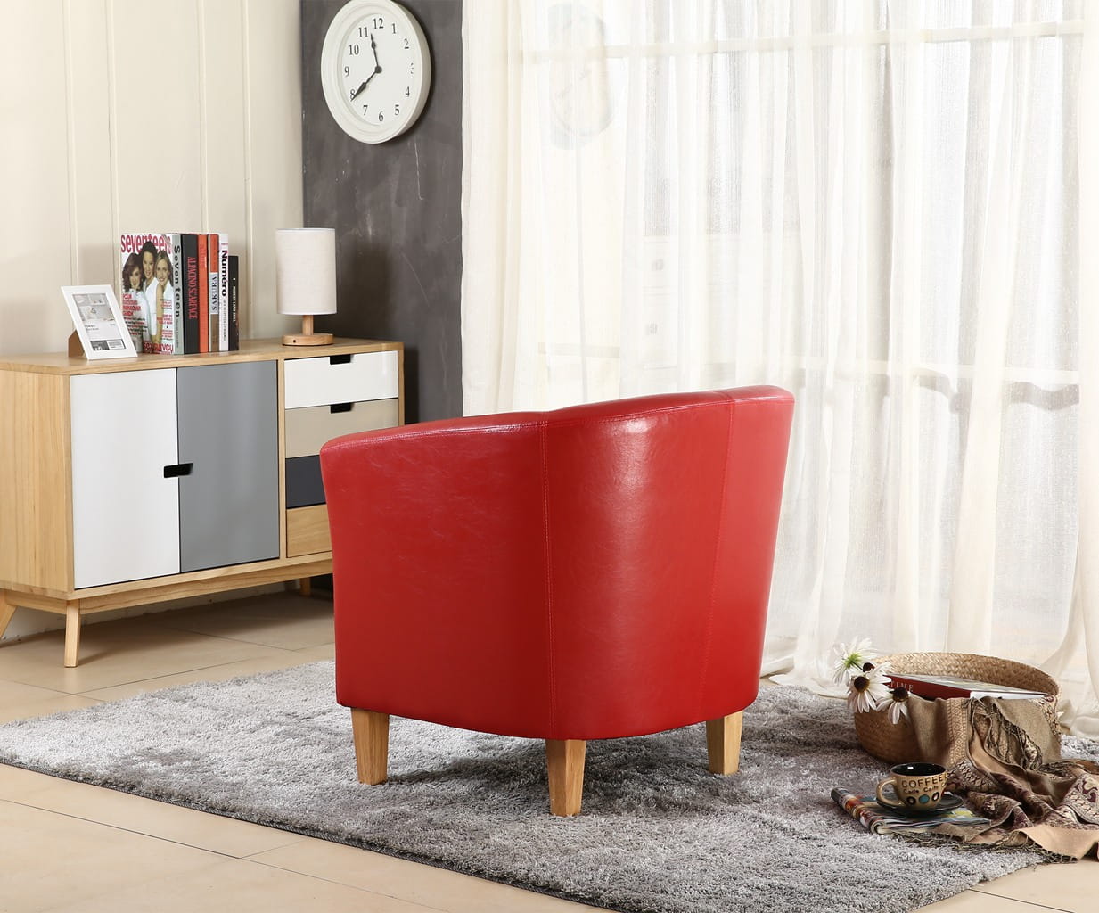 Red faux leather armchair in a living room setting with a wooden cabinet and clock on the wall.