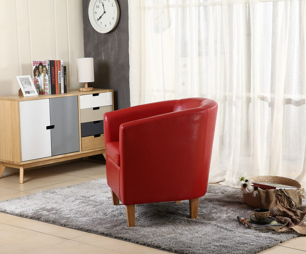 Red faux leather armchair in a living room setting with a wooden cabinet and clock on the wall.