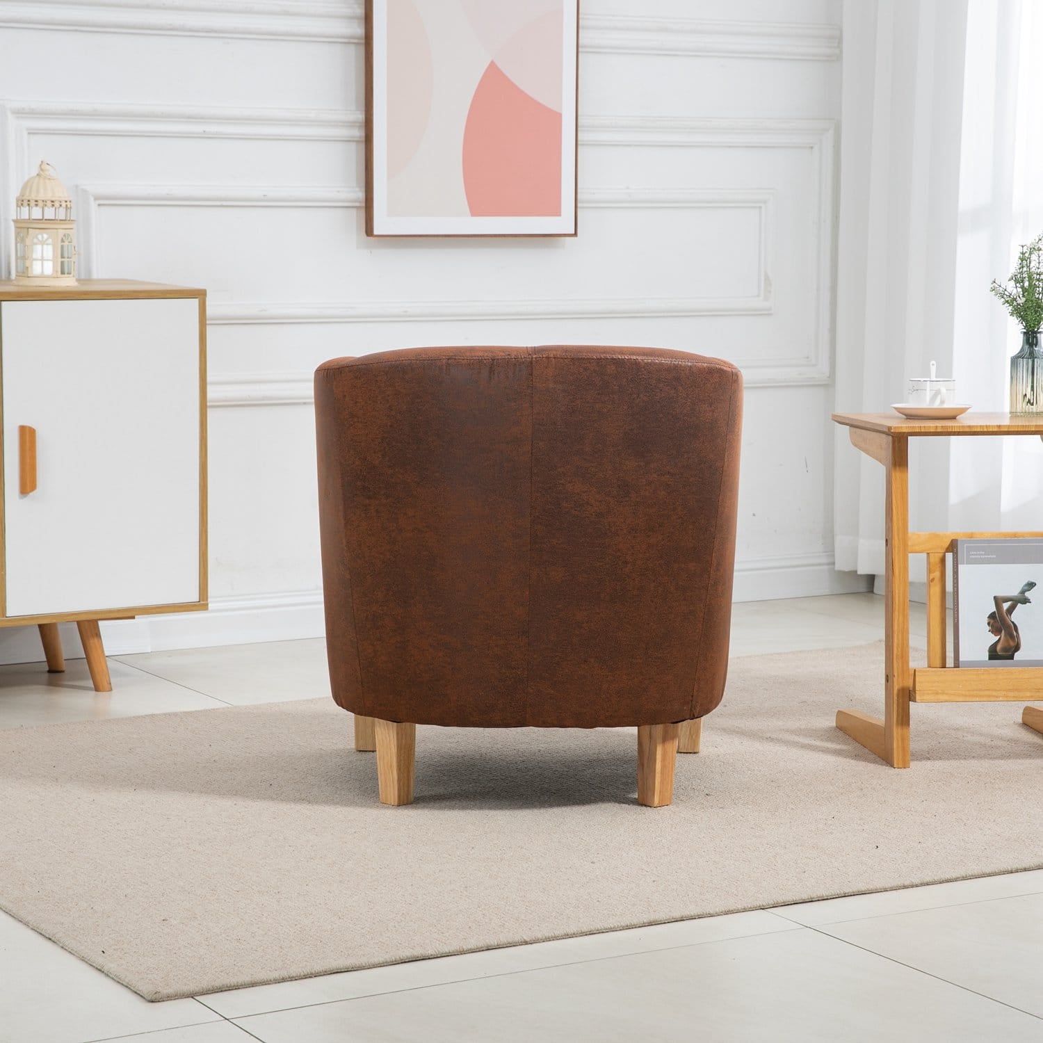 Vintage brown faux leather armchair in a room with white walls and wooden furniture.