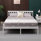 White wooden double bed frame with grey bedding and pillows in a bedroom setting.