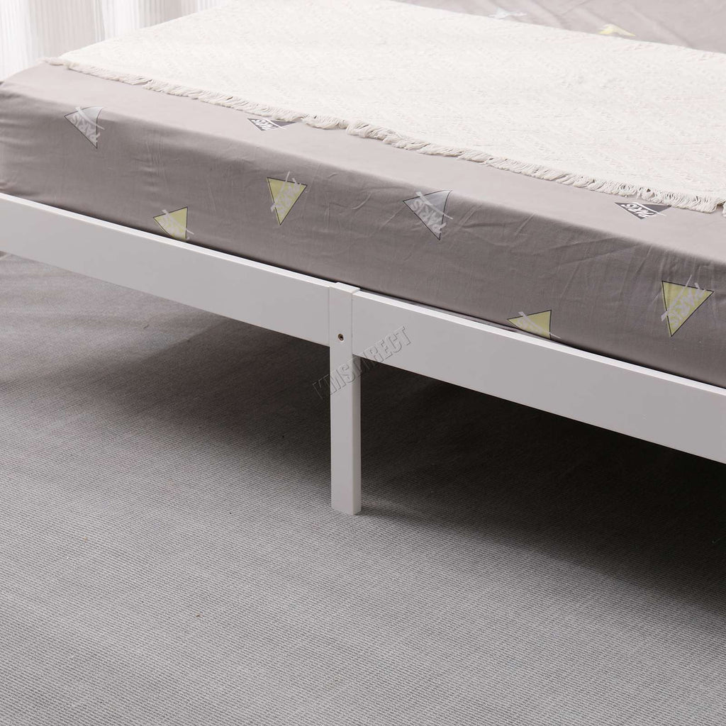 Grey mattress with a white frame from the wooden double bed on a grey carpeted floor