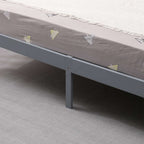 Grey wooden double bed frame with mattress on a grey carpeted floor.