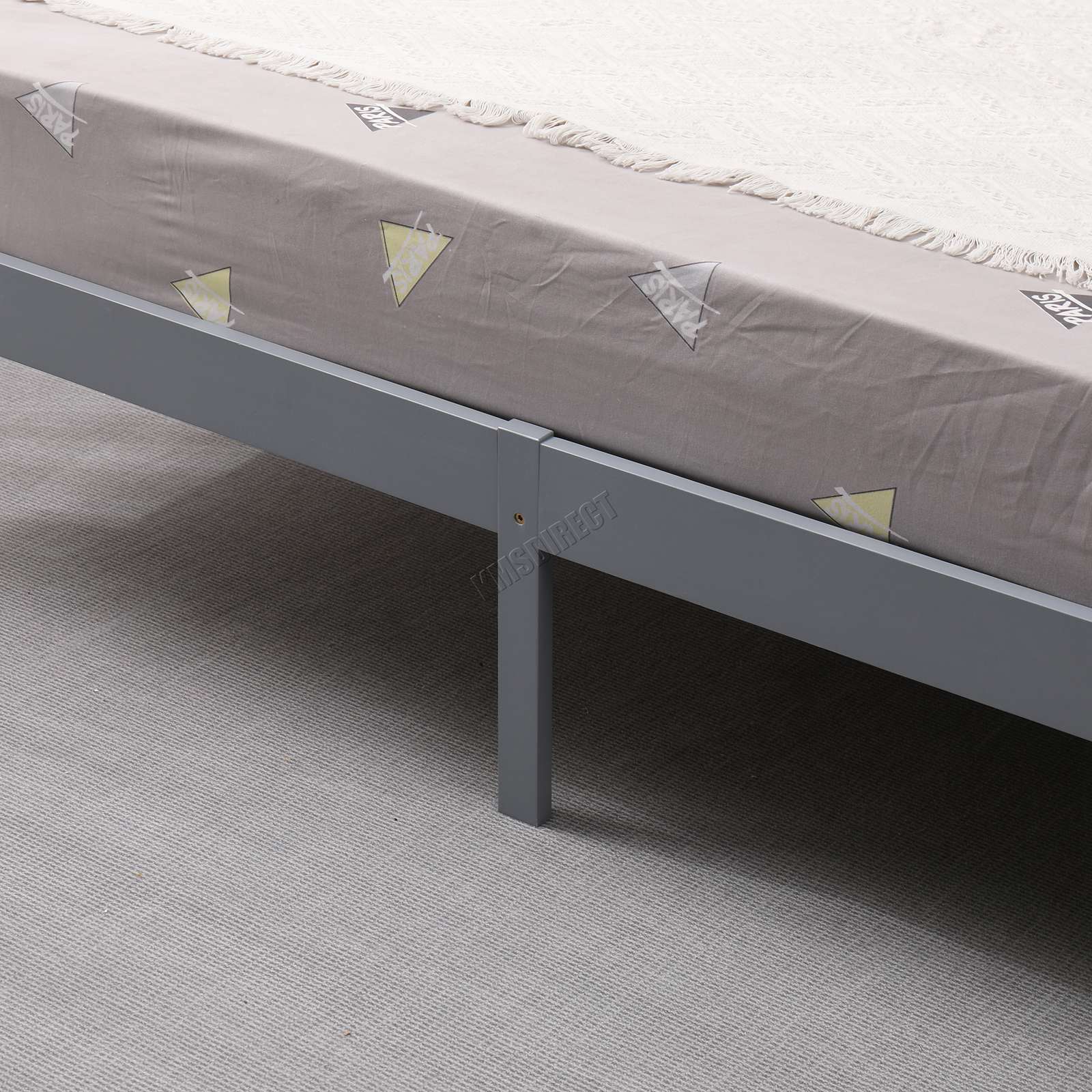 Grey wooden double bed frame with mattress on a grey carpeted floor.