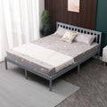 Grey wooden double bed frame with mattress and bedding in a room setting. 
